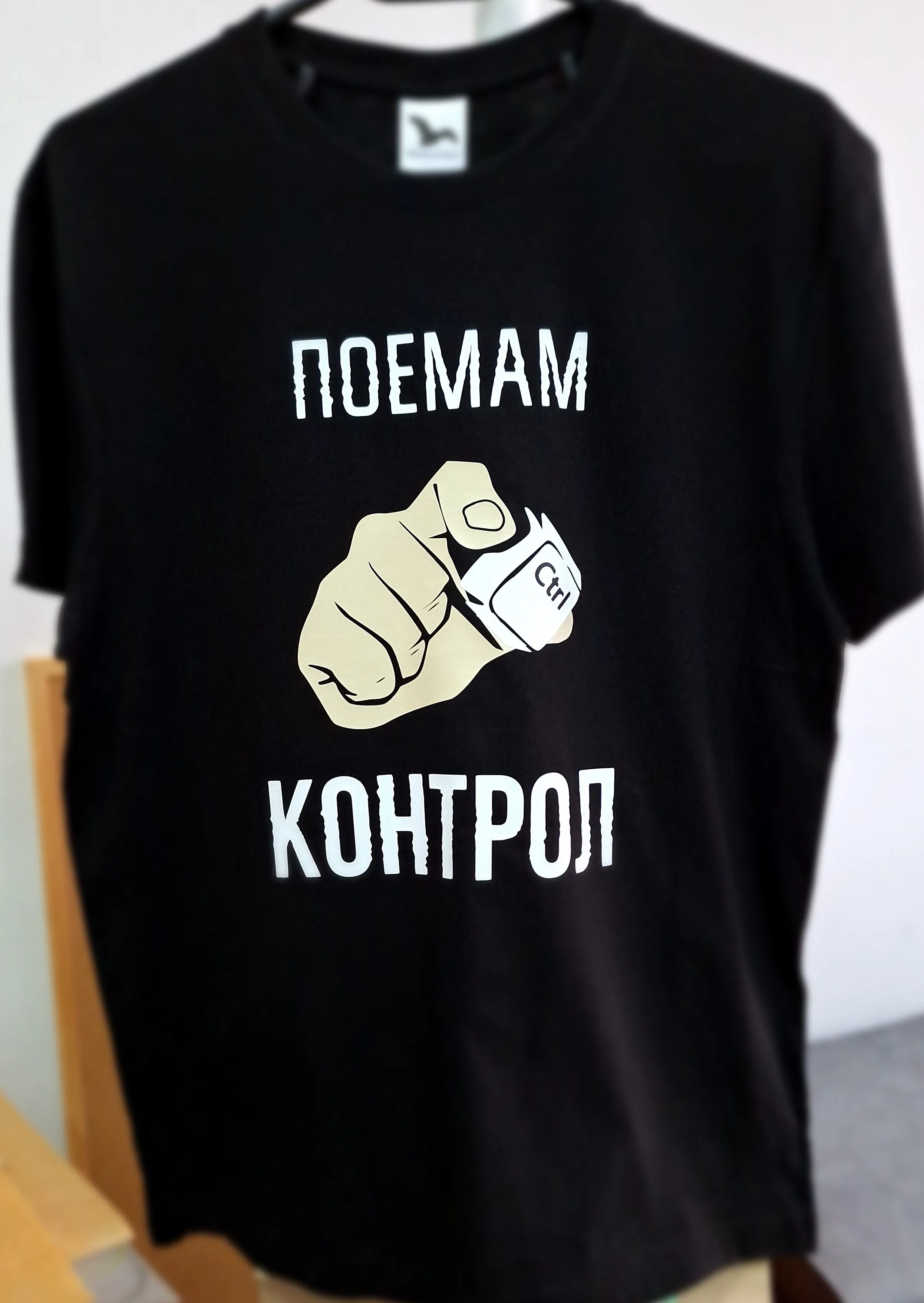 Мъжка черна тениска с ръка, държаща копче Ctr и надпис Поемам контрол